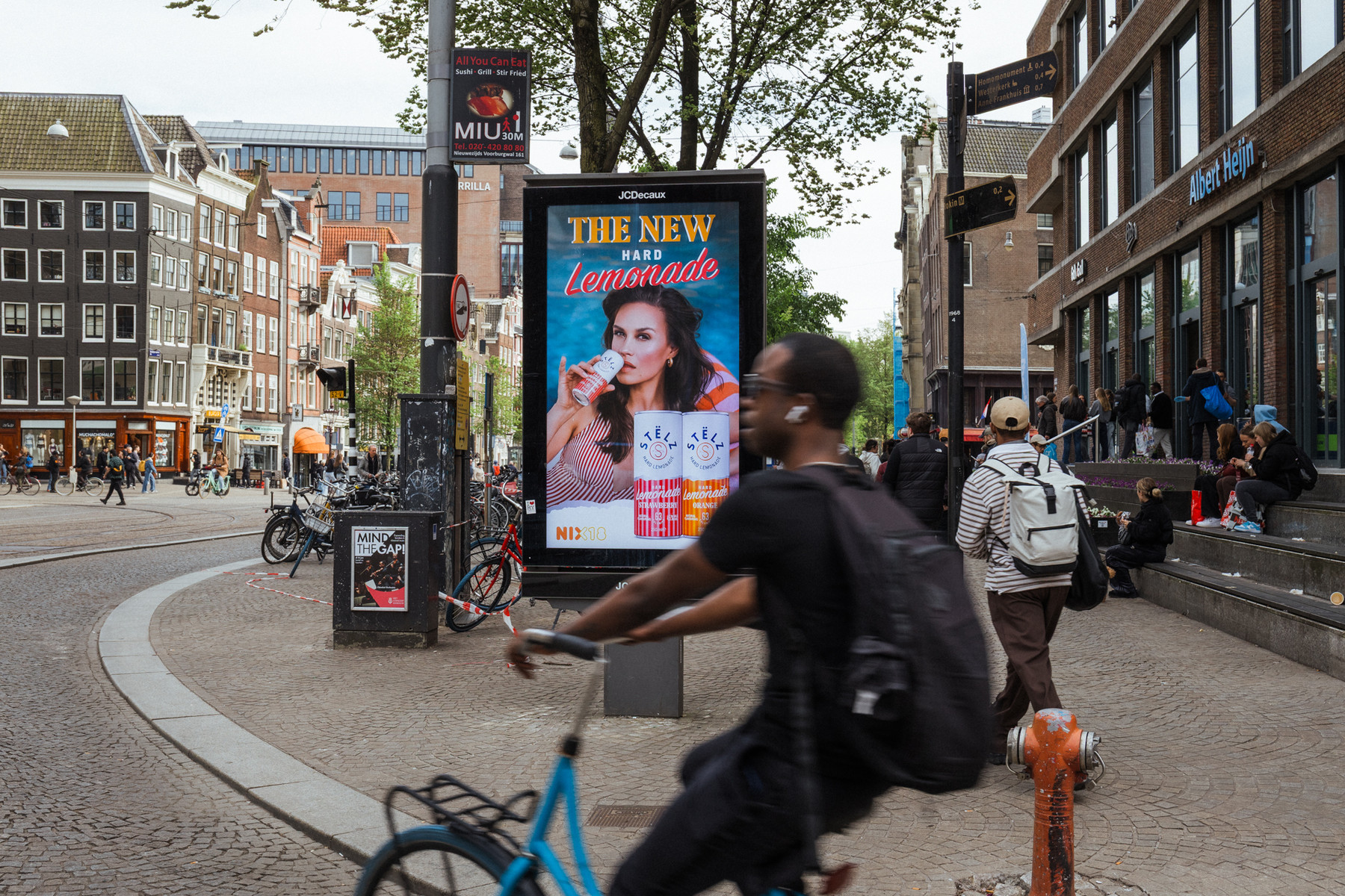 A freestanding digital advertising panel on a square in Amsterdam, carrying a booked campaign.
