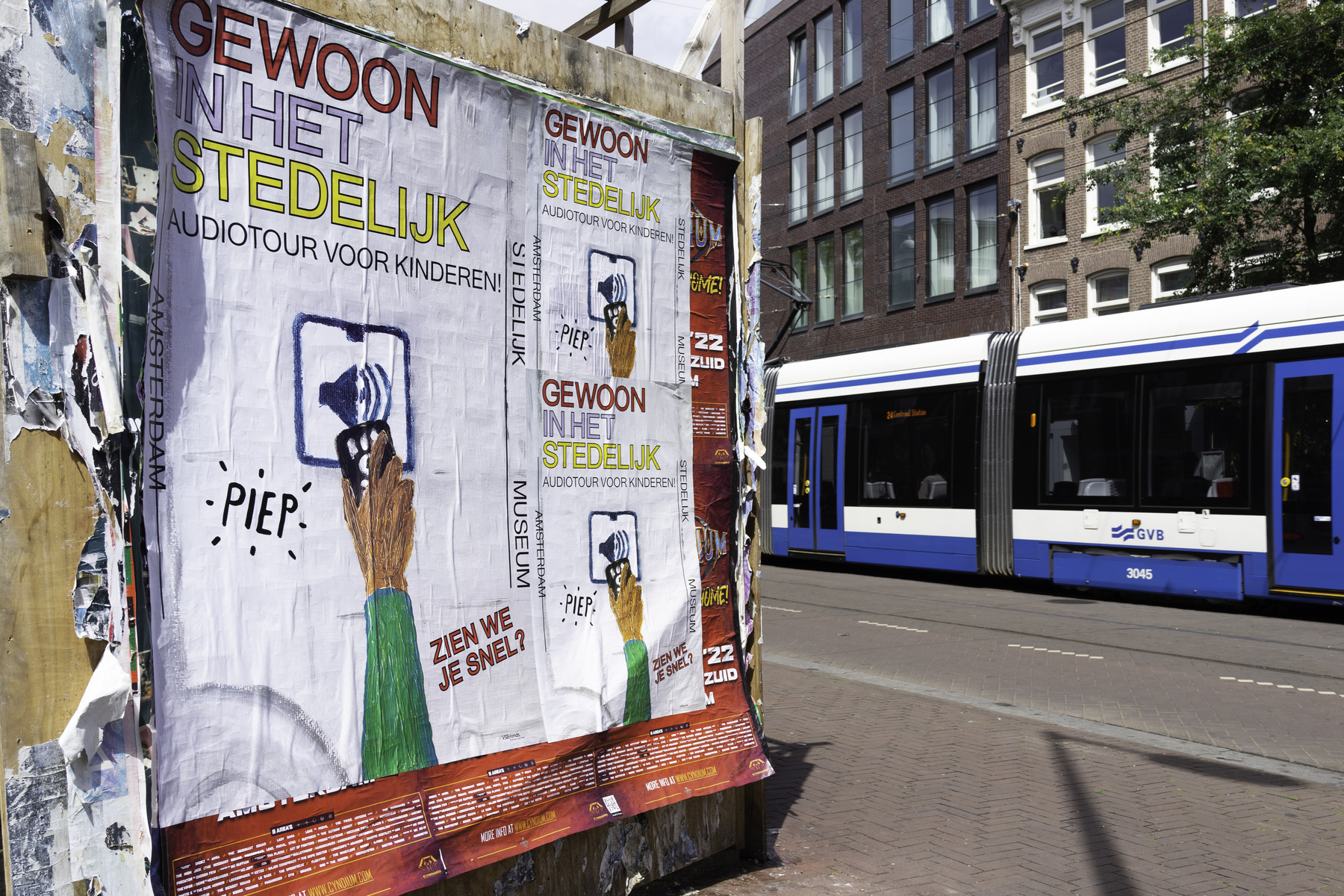 A construction hoarding in Amsterdam covered edge to edge with pasted posters.
